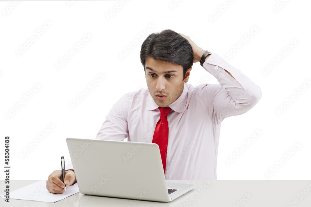 Businessman using a laptop and looking shocked Businessman using a laptop and looking shocked