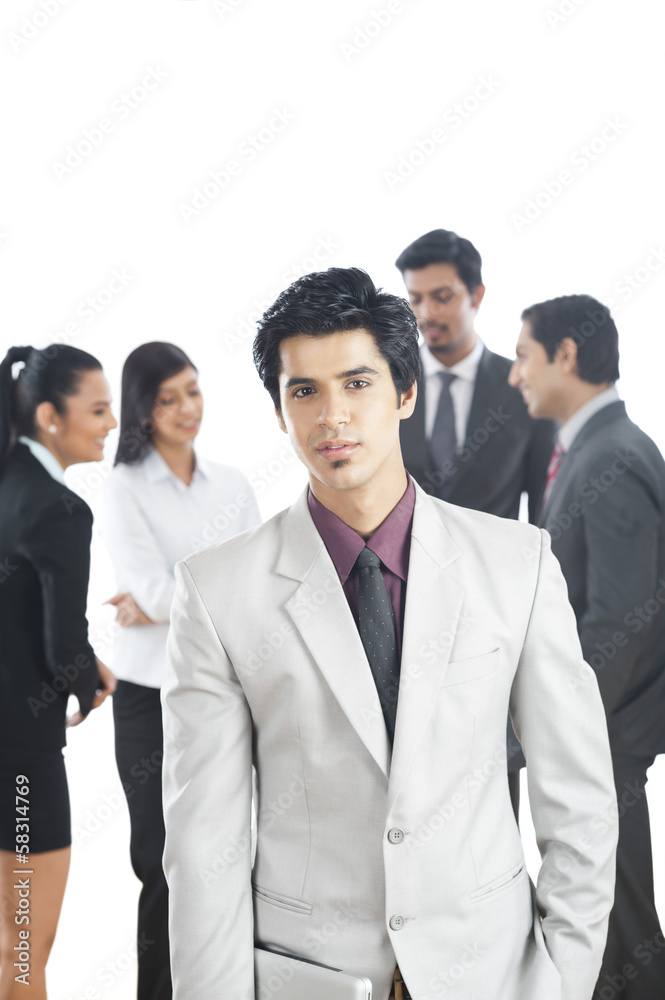 Portrait of a businessman with his colleagues in the background Portrait of a businessman with his colleagues in the background