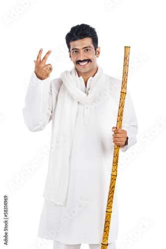 Bild auf Leinwand Portrait of a man holding a wooden staff and smiling