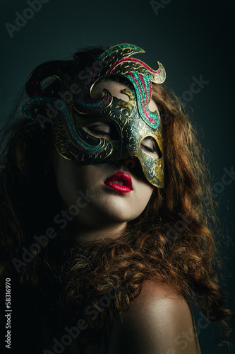 Beautiful Girl in Carnival mask with long curly hair.