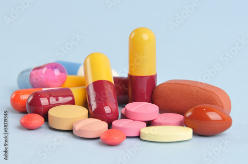 assortment of colorful pills and tablets isolated in blue