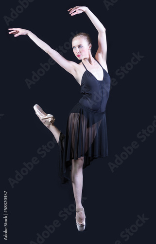 Ballet dancer in black dress isolated on gray background