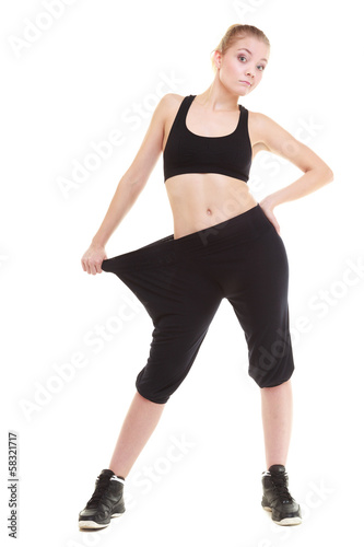 happy woman showing how much weight she lost, big pants