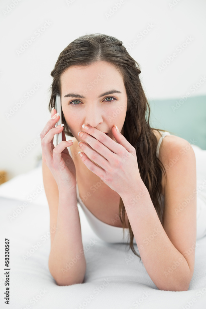 Shocked young woman using mobile phone in bed Shocked young woman using mobile phone in bed