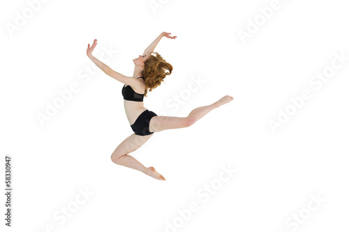 Side view of a sporty young woman jumping
