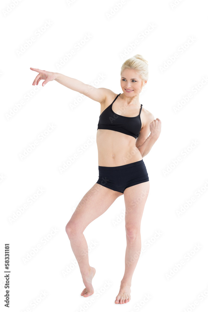 Full length of a sporty young woman pointing away Full length of a sporty young woman pointing away