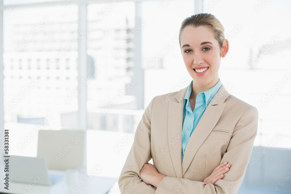 Fototapeta premium Lovely smiling chic businesswoman posing with arms crossed smili