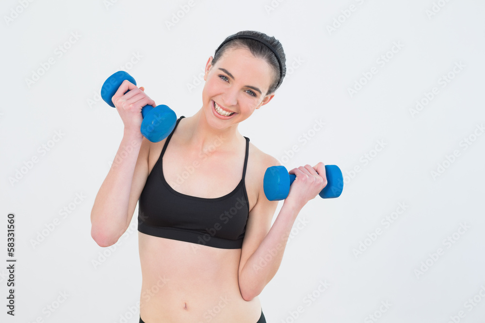 Woman with dumbbells against wall at fitness studio Woman with dumbbells against wall at fitness studio