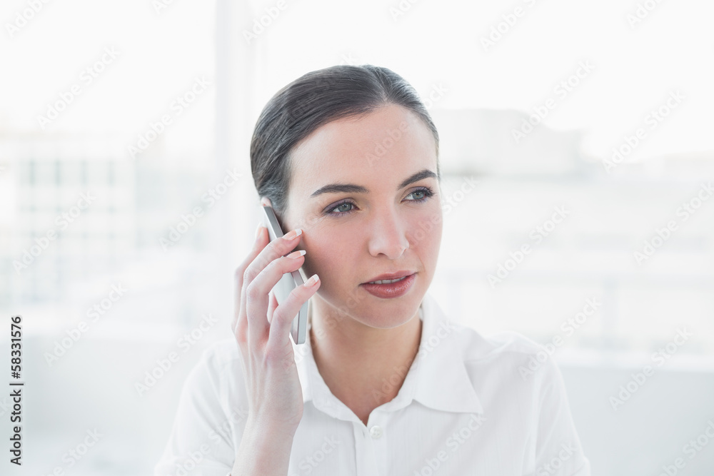Serious businesswoman using mobile phone in office Serious businesswoman using mobile phone in office