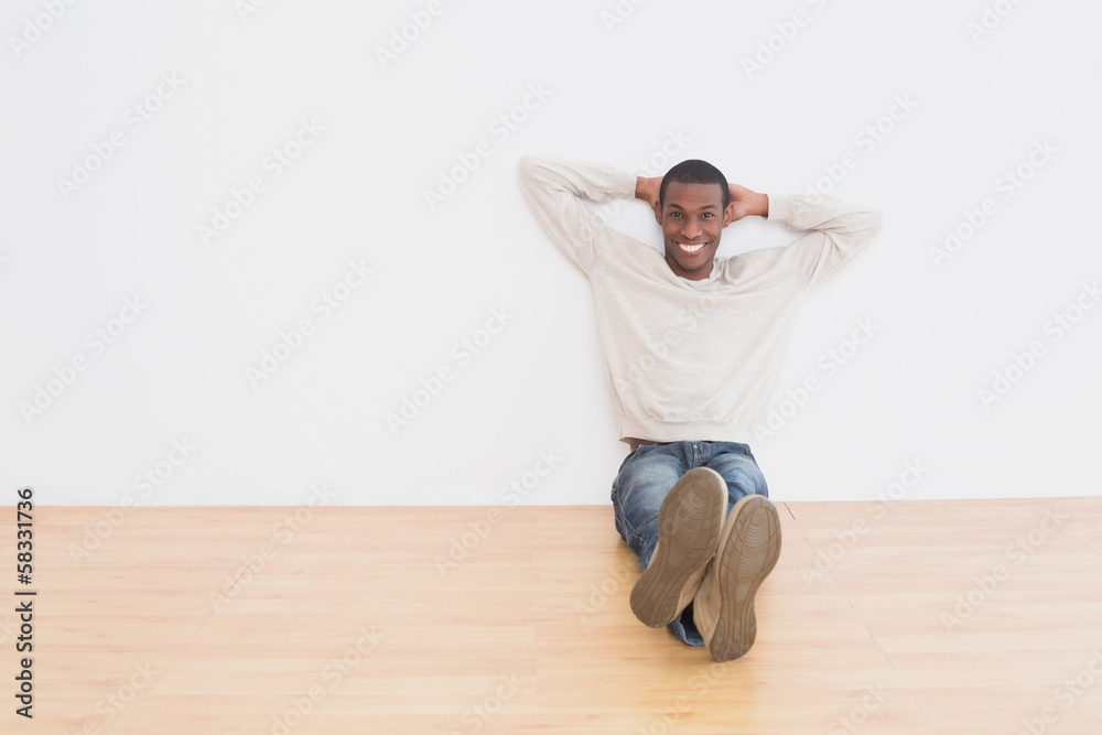 Afro young man sitting on floor in an empty room Afro young man sitting on floor in an empty room