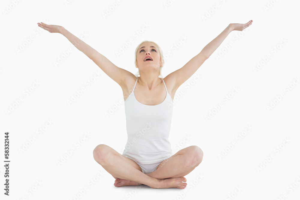 Toned young woman sitting with arms outstretched Toned young woman sitting with arms outstretched