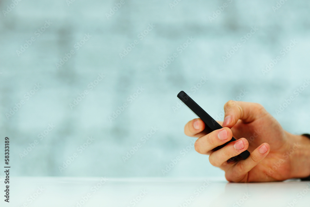Closeup image of a male hand typing on smartphone