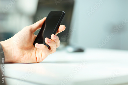 Closeup image of a male hand holding smartphone