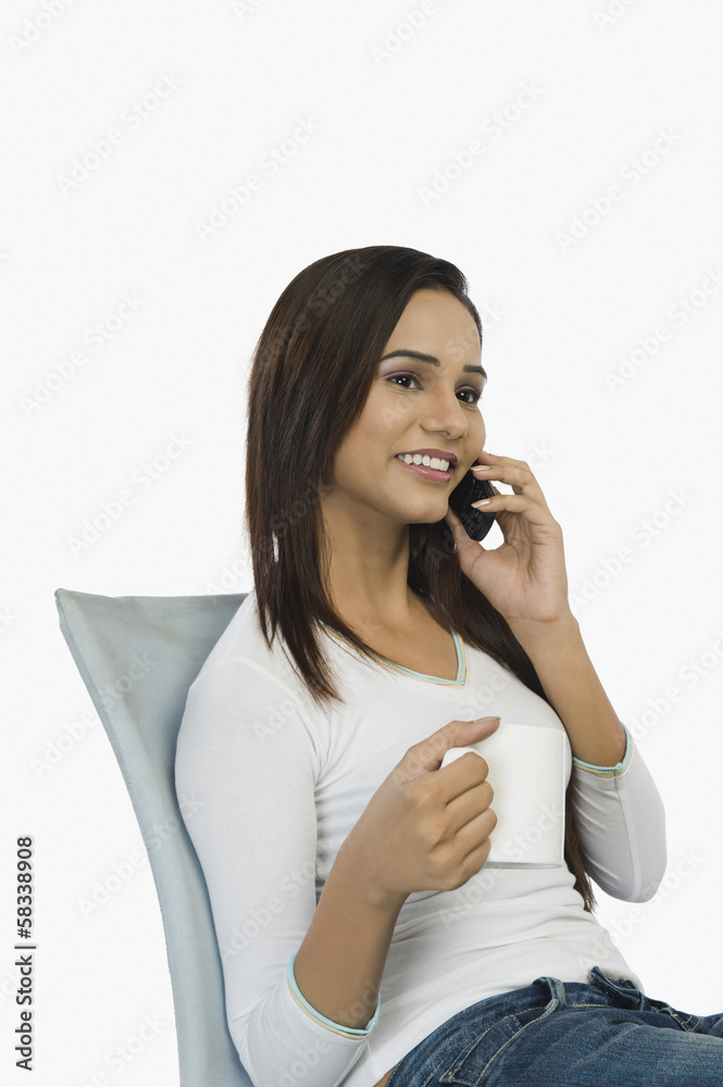 Woman talking on a mobile phone and drinking coffee Woman talking on a mobile phone and drinking coffee