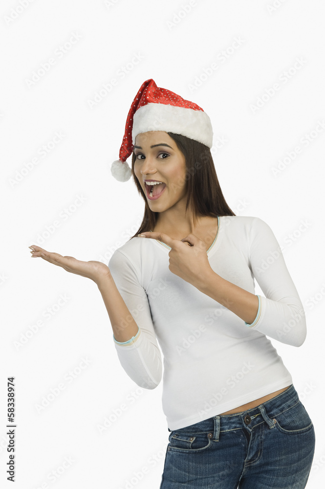 Woman wearing a Santa hat and gesturing Woman wearing a Santa hat and gesturing
