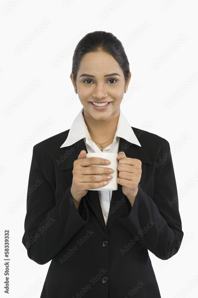 Businesswoman holding a cup of tea and smiling Businesswoman holding a cup of tea and smiling