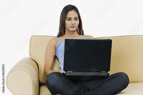 Woman sitting on a couch and using a laptop