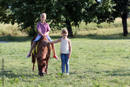 boy and little girl with pony horse pet