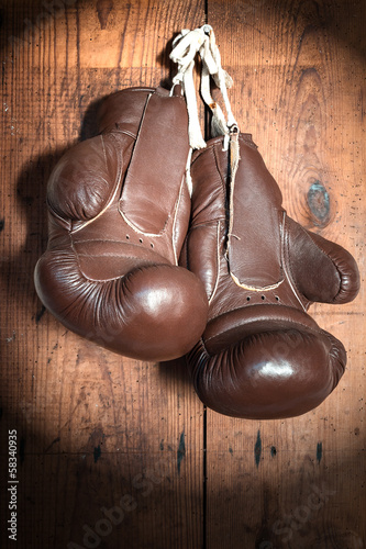 old Boxing Gloves, on wooden wall in the Spotlight © Ezio Gutzemberg