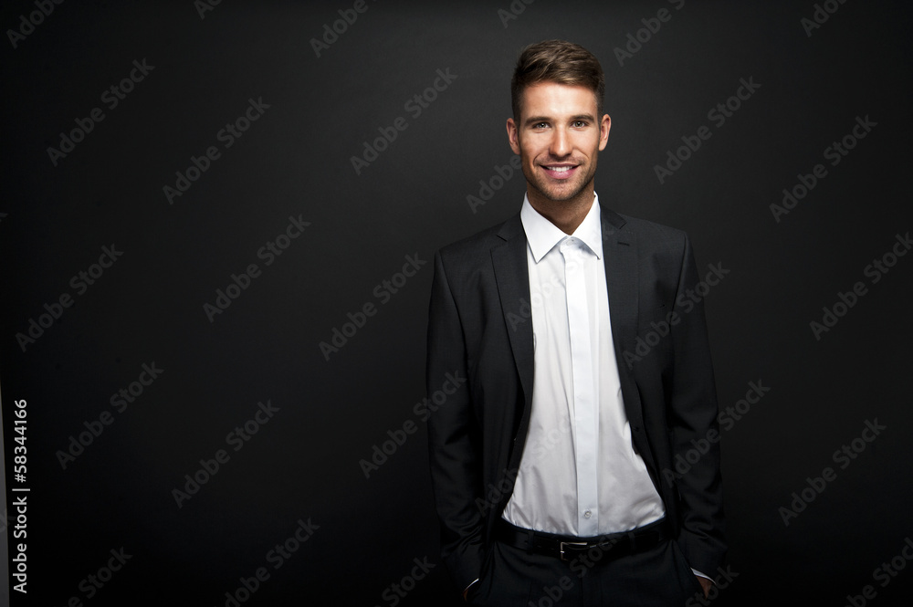 Businessman standing on dark gradient background Businessman standing on dark gradient background