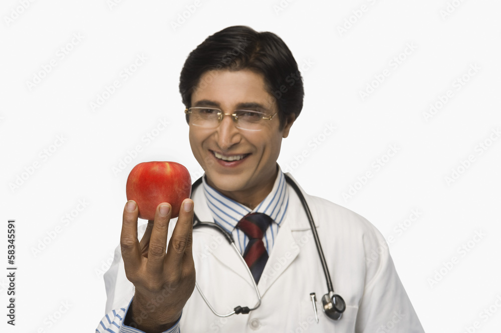 Doctor holding an apple and smiling