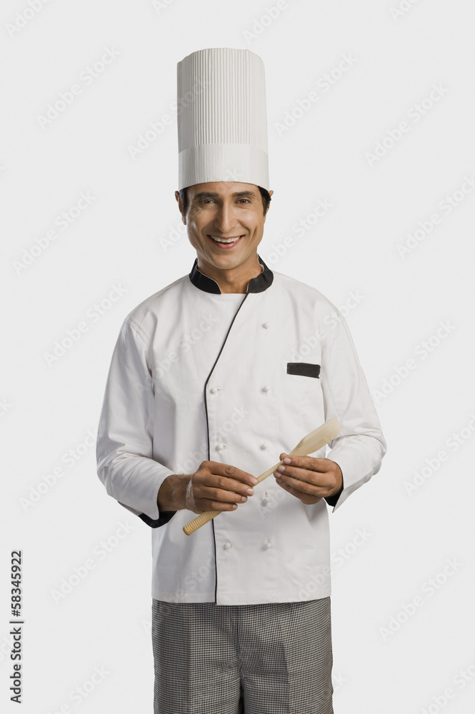 Portrait of a chef holding a wooden spoon