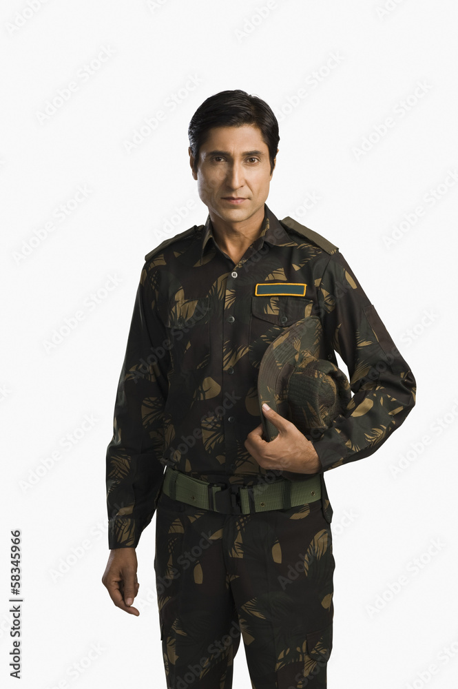 Portrait of an army soldier holding a cap