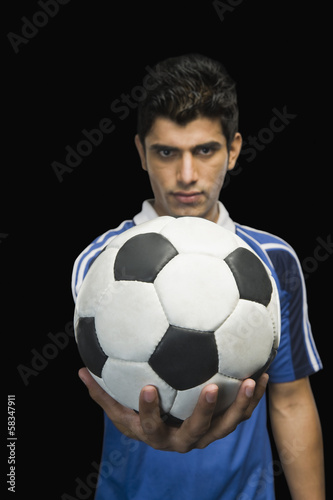 Soccer player showing a soccer ball © imagedb.com