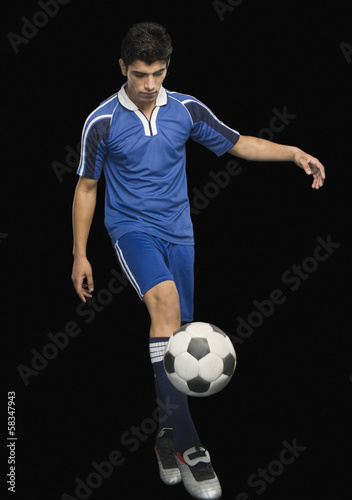 Fototapeta Naklejka Na Ścianę i Meble -  Soccer player practicing with a soccer ball