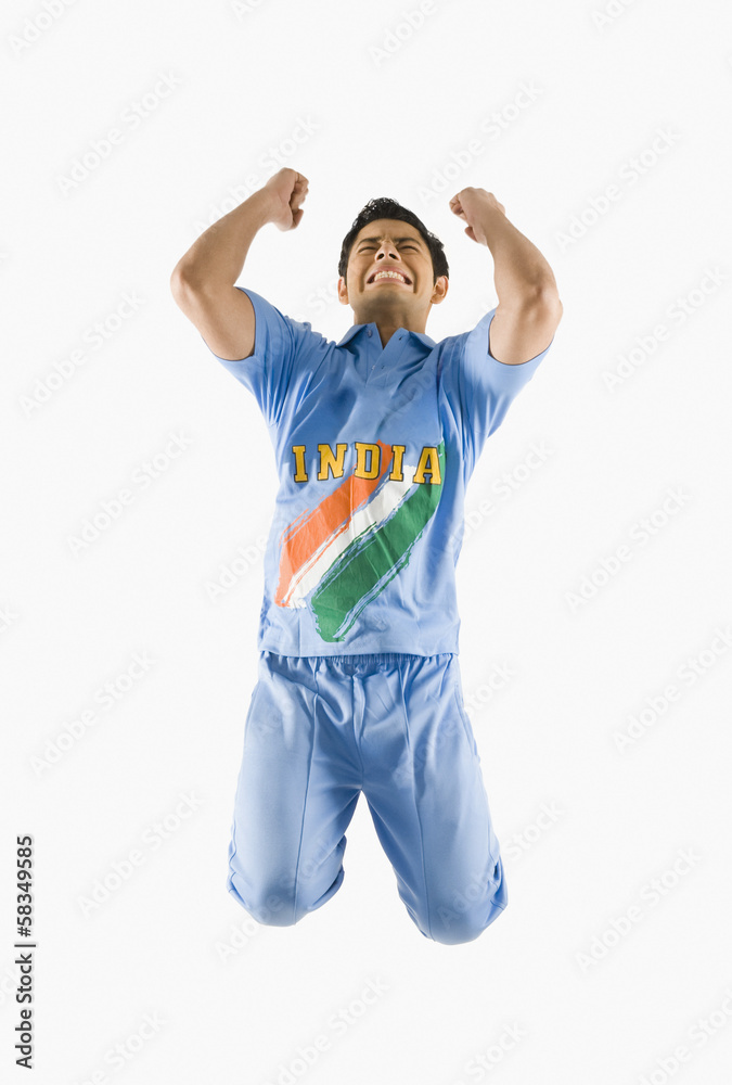 Cricket bowler celebrating with his arms raised