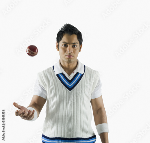 фотографія Portrait of a cricket bowler tossing a ball