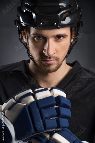 Portrait of handsome hockey player in black helmet.