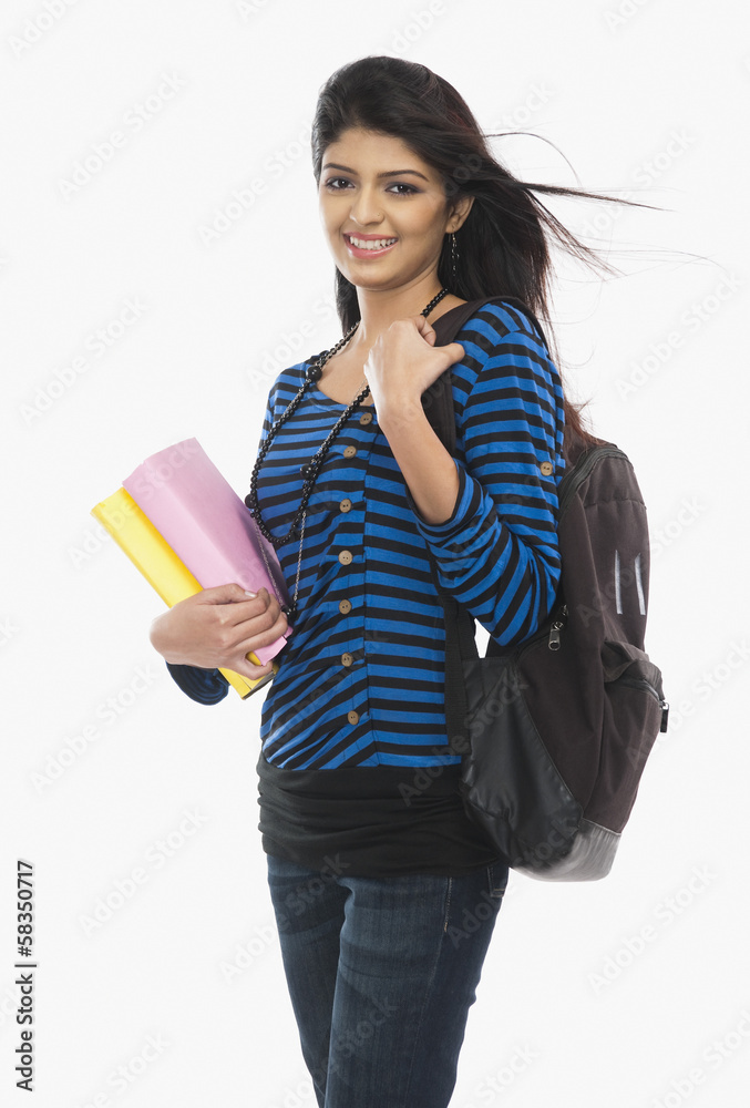 Female university student holding books and smiling Female university student holding books and smiling