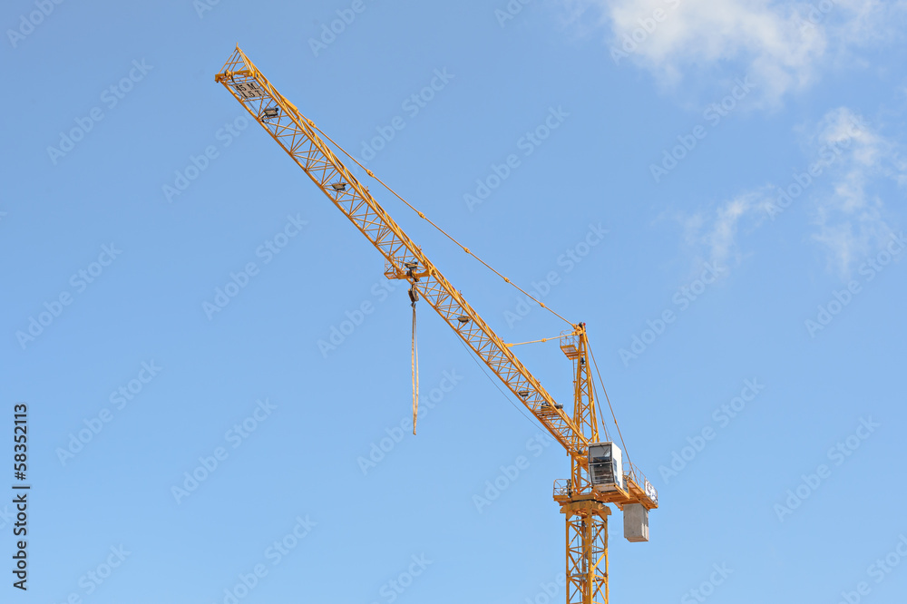 Crane at construction site against blue sky. Crane at construction site against blue sky.