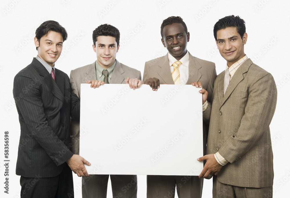 Portrait of four businessmen showing a blank placard Portrait of four businessmen showing a blank placard