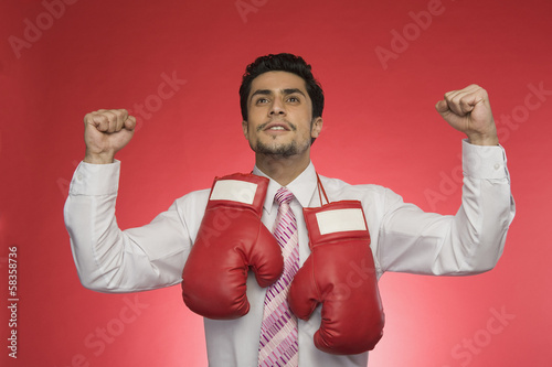 Businessman with boxing gloves clenching his fists