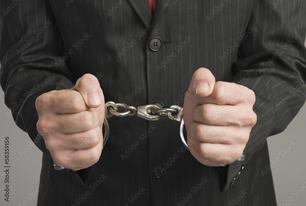 Fototapeta premium Close-up of a businessman tied up with handcuffs