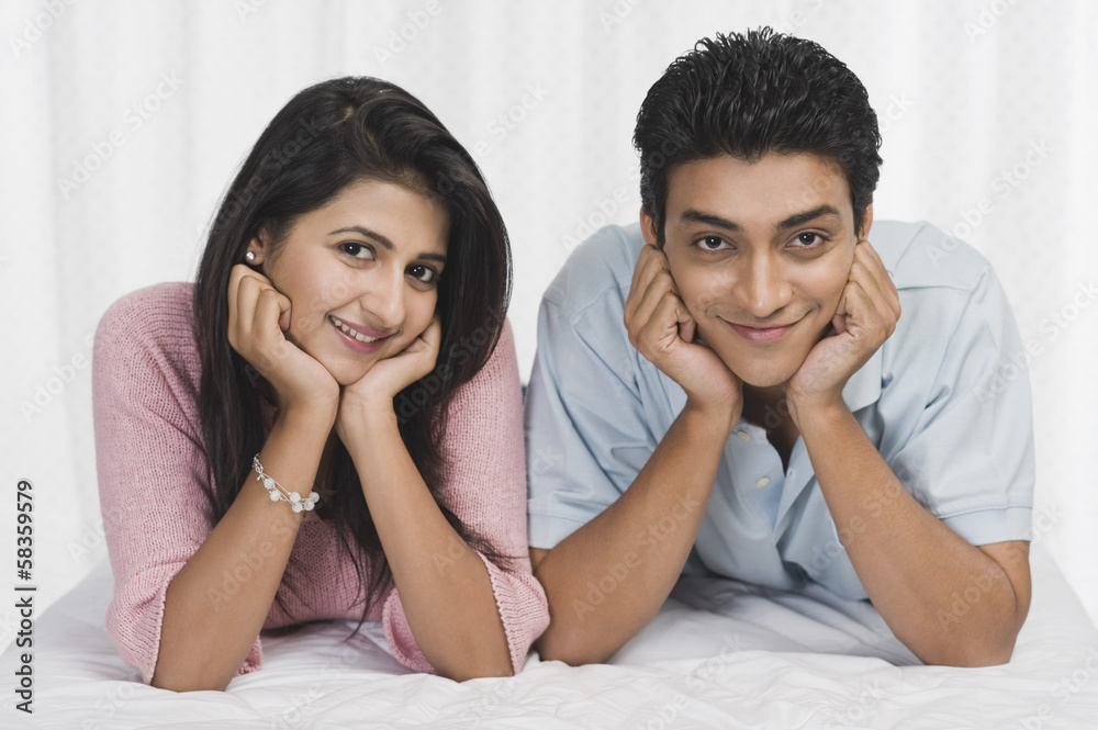 Portrait of a couple lying on the bed and smiling Portrait of a couple lying on the bed and smiling