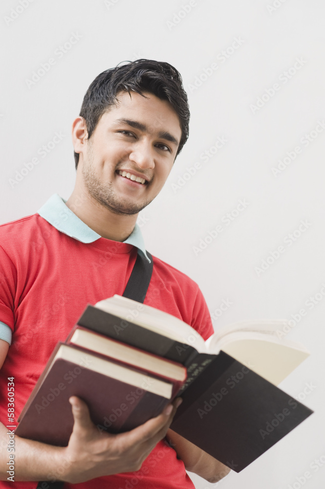 Portrait of a man holding books and smiling Portrait of a man holding books and smiling