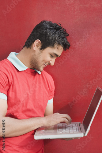 Man working on a laptop and smiling