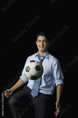 Businessman playing with a soccer ball © imagedb.com