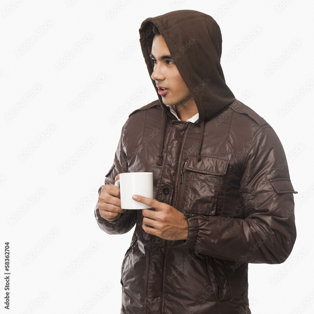 Man holding a cup of coffee and looking away Man holding a cup of coffee and looking away