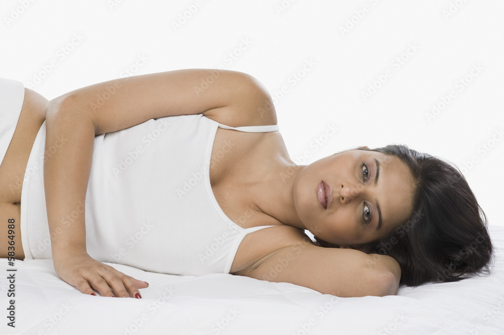 Fototapeta premium Portrait of a woman lying on the bed