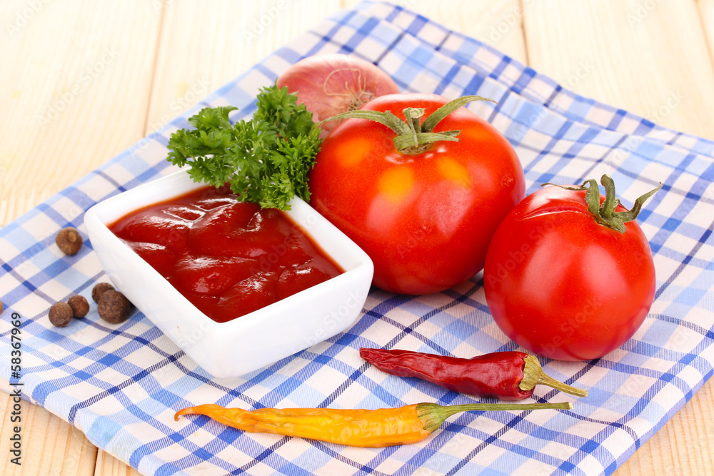 Ketchup and ripe tomatoes on wooden table Ketchup and ripe tomatoes on wooden table