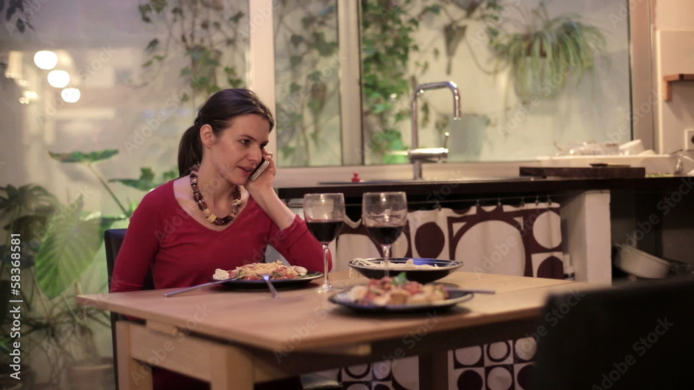 Angry, unhappy woman talking on cellphone, waiting with dinner Angry, unhappy woman talking on cellphone, waiting with dinner