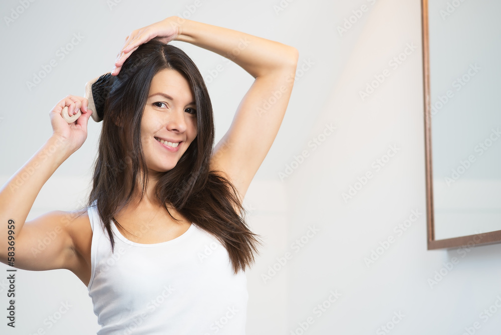 Attractive young woman brushing her long hair Attractive young woman brushing her long hair