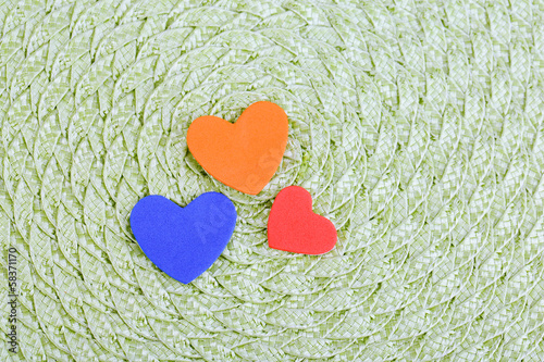 Hearts made of felt on green background