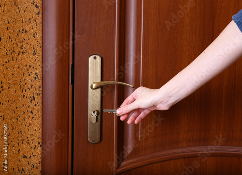 Locking up or unlocking door with key in hand