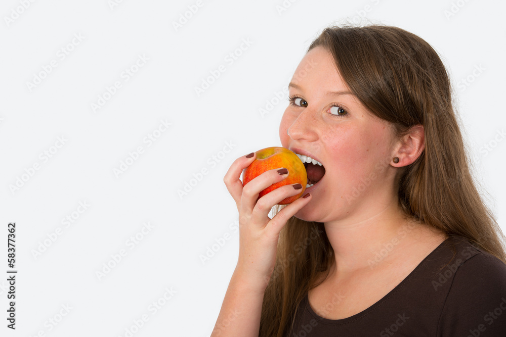 young woman is biting in a apple young woman is biting in a apple
