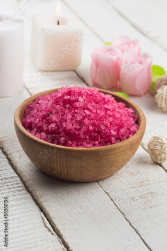 Sea salt in bowl with candle on wooden background